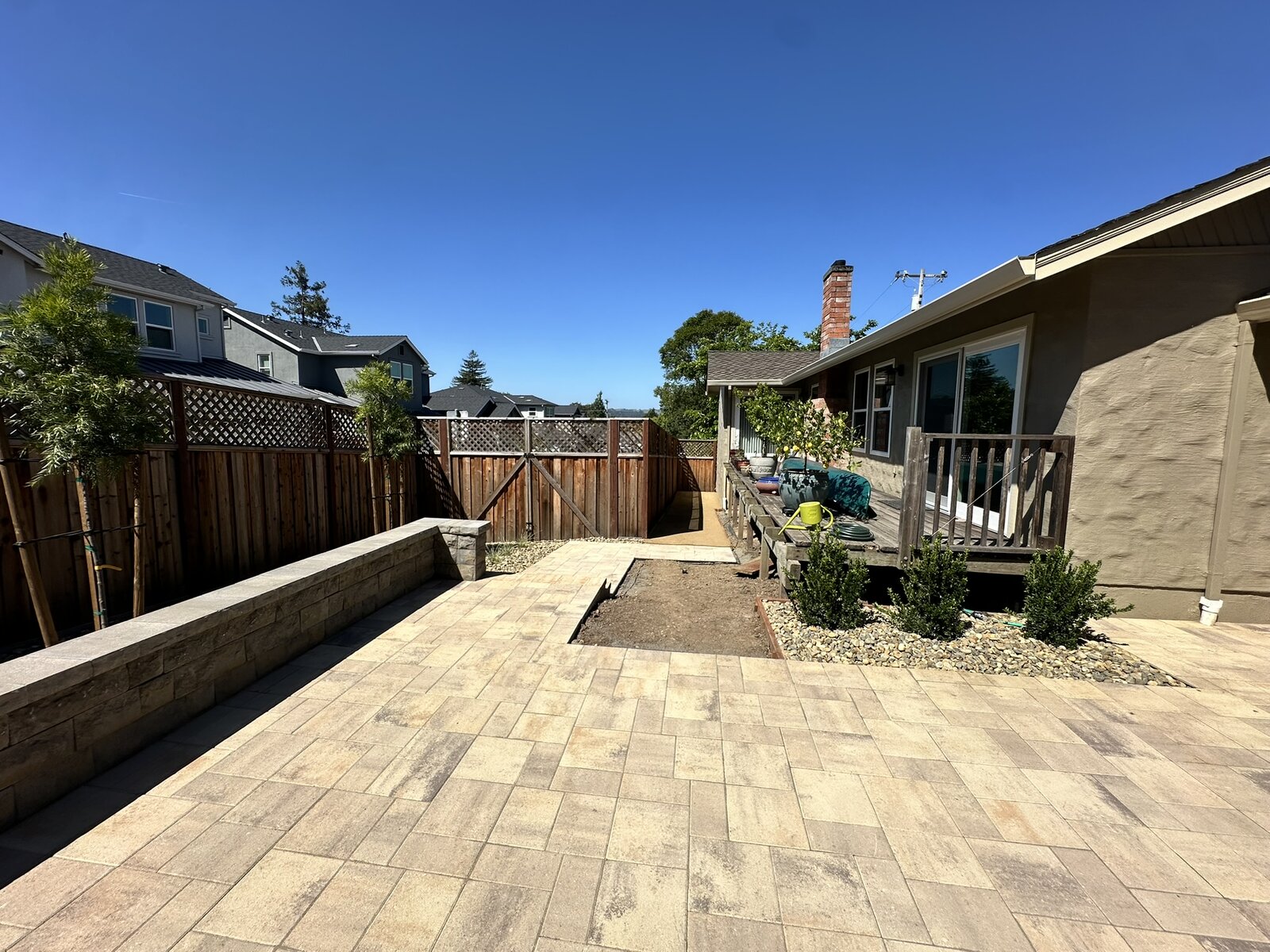 Aerial view completed — paver patio, retaining walls, plantings, and new deck from above